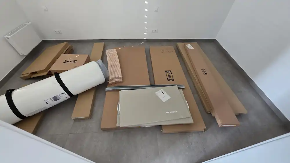 Cartons IKEA non montés dans une chambre au Luxembourg avant intervention La Fourmi